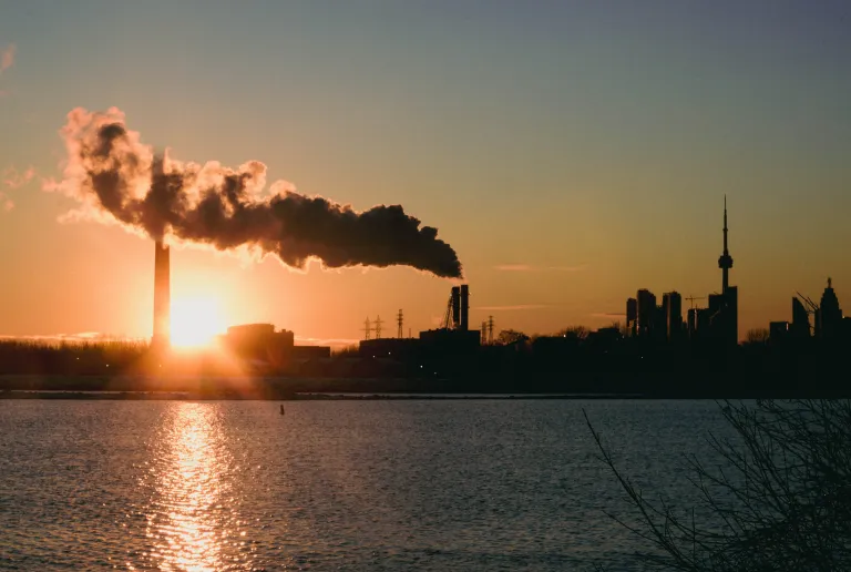 Grauer Rauch aus Schornsteinen bei Sonnenuntergang